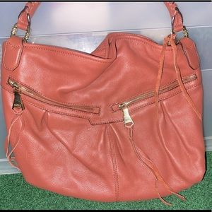 Coral leather satchel with fringe detail.